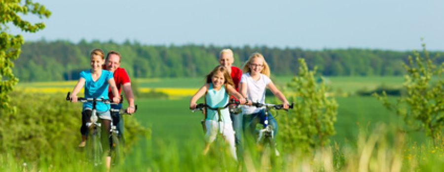 Family cycling outdoors in summer